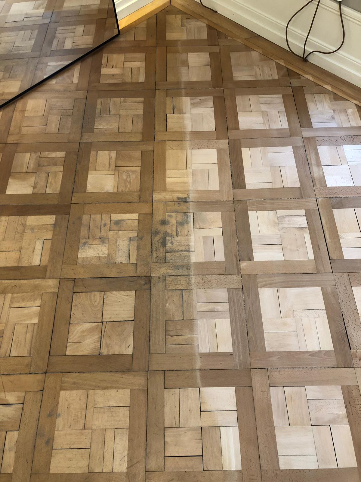Abgenutztes Mosaikparkett mit Gebrauchsspuren vor der Aufarbeitung