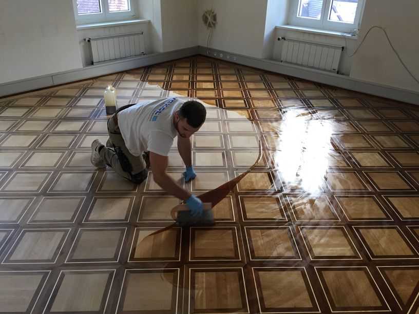 Parkettleger bei der Arbeit auf einem Mosaikparkett